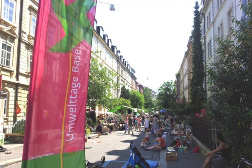 Strasse mit Quartierflohmarkt und Umwelttage-Beachflag im Vordergrund