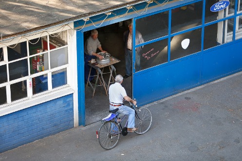 Ein Fahrradfahrer fährt an einem Laden vorbei