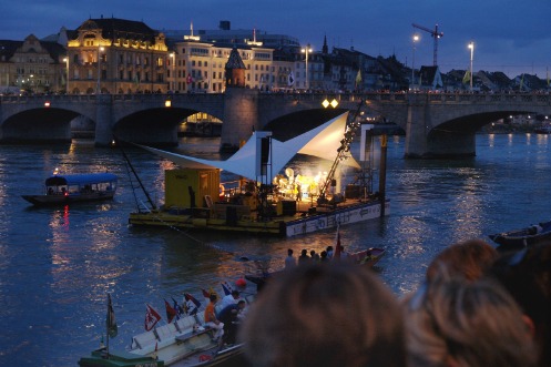 Konzert in der Abenddämmerung auf dem beleuchtetes Kulturfloss vor der mittleren Rheinbrücke