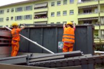 Bauarbeiter beim Ablegen einer Mulde